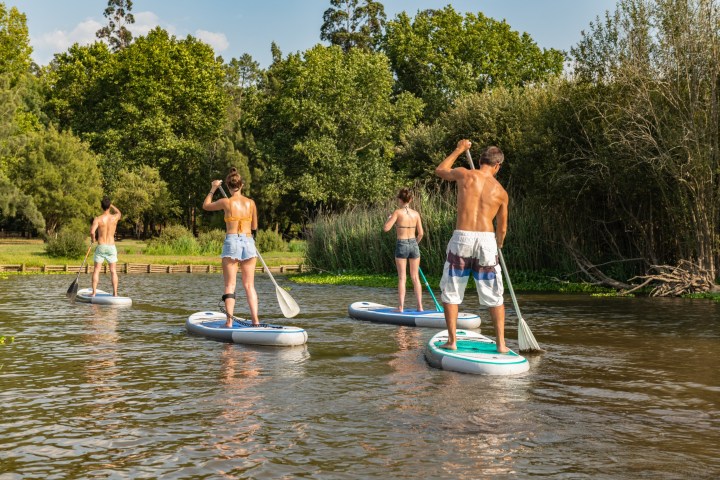 a group of people riding on the back of a boat in the water