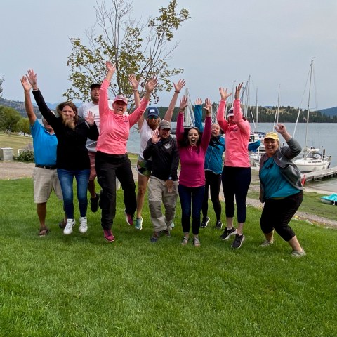 a group of people standing on top of a grass covered field
