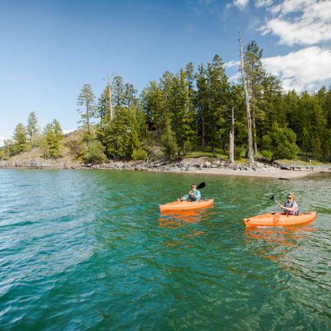 a group of people riding on the back of a boat in the water
